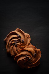 Two Chocolate chip cookies on a black background. Top-down view. Food Flat lay.