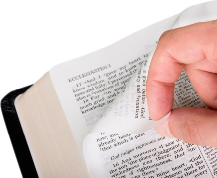 Closeup on a Hand Turning a Page of the Bible