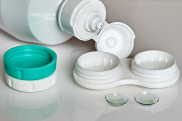 Contact lenses, a bottle of cleaning liquid and a container for them. The topic of medicine and health care. Up close