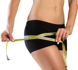 Female fitness model holding a tape measurer around her waist - weightloss concept