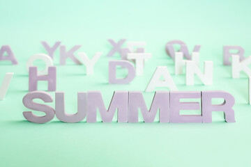 letters forming word SUMMER. the word SUMMER against the background of other letters