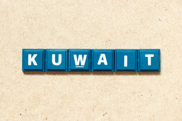 Tile alphabet letter in word kuwait on wood background