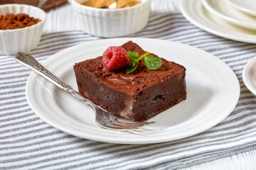 Fototapeta na wymiar chocolate brownies with fresh raspberry and mint