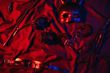 Handcuffs, leather whip flogger, mask and choker for BDSM sex with submission and domination....