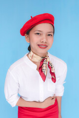A flight attendant or a stewardess with her arms on her stomach. A hostess bowing down to passengers. Isolated on a blue background.