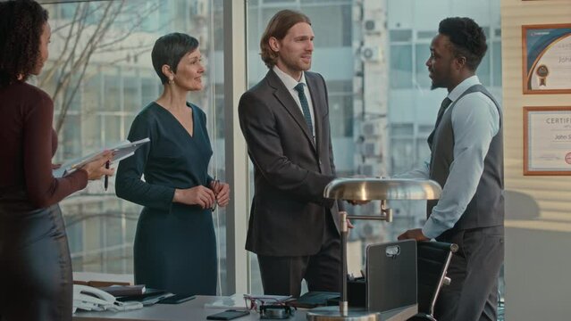 Medium shot of diverse business team and secretary having negotiations in successful company