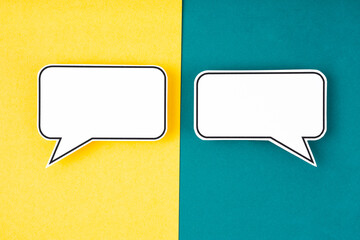 The White speech bubble shaped post it note on green and yellow background with copy space.