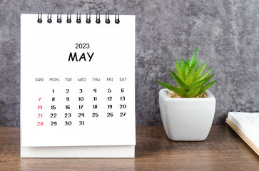 The May 2023 Monthly desk calendar for 2023 with diary on wooden table.