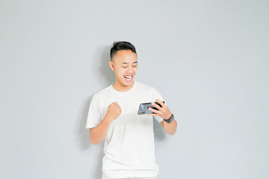a young Asian is happy when he wins the game