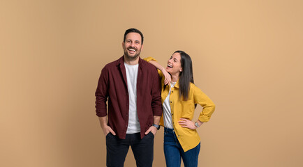Beautiful woman with hand on boyfriend's shoulder looking at him and laughing. Charming young...