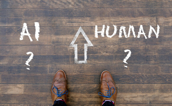 Man looking down at the words Artificial Intelligence - AI - and Human chalked onto the floor