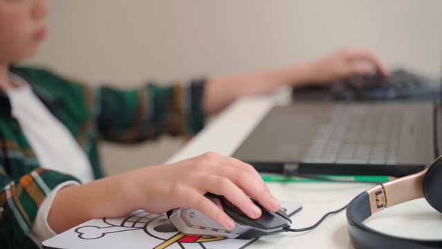 Close up child hand typing computer gamer keyboard mouse, kid playing video game with laptop. Hobby leisure activity, children unhealthy technology addiction. High quality 4k footage