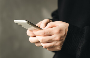Smartphone in the hands of a man close-up on a blurred background, the concept of using technology, shopping online, communicating remotely.