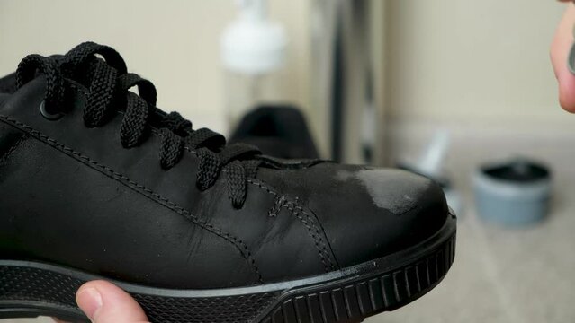 The process of applying a water-repellent spray to black men's nubuck demi-season shoes