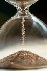 Shiny sand running in inverted hourglass lasting certain amount of time as transience of life....