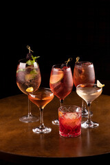 collection of refreshing cocktail glass in party of lillet spritz aperol with lemon red fruits and negroni mint and ice with black background round table