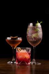 collection of refreshing cocktails and drinks involving negroni martini whiskey and glass of white wine with ice berries and mint on a black background