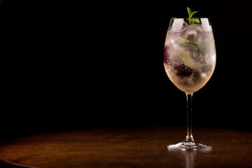 glass of refreshing cocktail with mint and berries and ice close-up in the corner