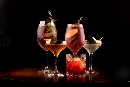 collection of refreshing party cocktail glass of lillet spritz aperol with lemon berries and mint and ice on wooden table with top view