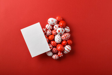 Easter backgrounds with a large egg and a blank sheet layout of Easter red and white eggs on a bright red background. Space for copying. Flat position, top view.