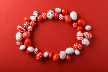 Easter backgrounds with an oval frame of Easter red and white eggs on a bright red background.