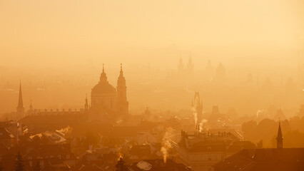 Prague cityscape in morning light. Towers of Lesser Town in autumn fog, Czech Republic..