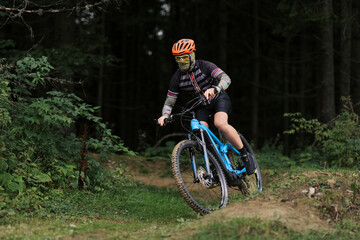 Fototapeta premium Cyclist Riding the Bike in the Beautiful Mountains Down the Rock on Background. Extreme Sport and Enduro Biking Concept