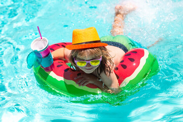 Happy child playing in swimming pool. Summer kids vacation. Child swim in poolside in water background.