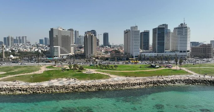 Aerial footage Tel Aviv beach promenade with the line of hotels in the background. Filmed in C4K Apple ProRes 422 HQ