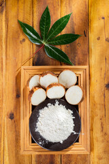 pile of cassava, and cassava flour on a background of rustic wood (Manihot esculenta)