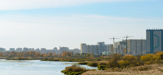 Naklejka premium Panorama with river and nature and residential high-rise buildings in the distance