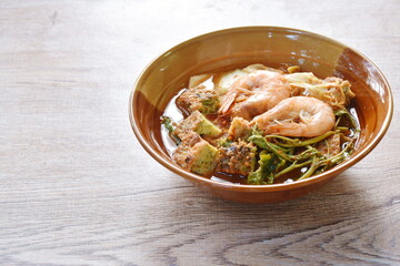 boiled shrimp and fried egg stuffed climbing wattle vegetable in spicy sour soup on bowl