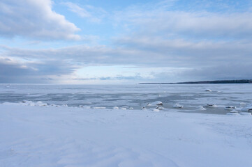 the seashore in winter. the sea is under ice and snow