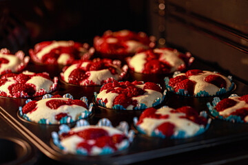 Himbeermuffins in einer Muffins Backform, backen in einem Ofen