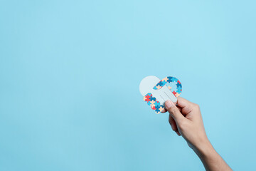 Hand puzzle symbol paper cut out of awareness for autism spectrum disorder family support. Autism World Awareness Day