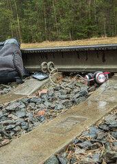 Railway crossing. on it lies a backpack, shoes, headphones. The concept of increased attention to paths.