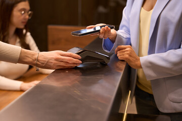 Fashionable client makes NFC payment at at front desk