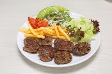 grilled meatballs served with fries and green salad