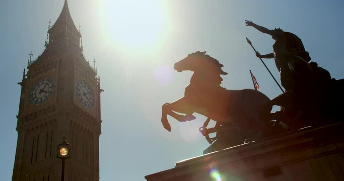 Big Ben, Houses of Parliament and Union Jack Flag flying over Boadicea or Boudica statue on Westminster Bridge, London, England
