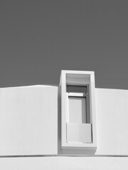 Simple lines of modern window on white facade view from outside in Portugal. Vertical black and white photo