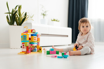 little toddler girl playing with colorful block