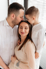 Father and son kissing mother on her birthday