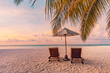 Tranquil sea sand sunset sky relaxing beach. Love couple  romantic freedom travel landscape concept. Idyllic exotic chairs umbrella, palm tree leaves, tropics beachfront resort. Summer vacation island