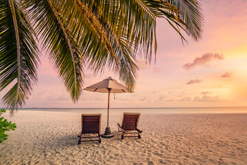 Tranquil sea sand sunset sky relaxing beach. Love couple  romantic freedom travel landscape concept. Idyllic exotic chairs umbrella, palm tree leaves, tropics beachfront resort. Summer vacation island