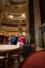 Happy couple taking selfie in recreation area of modern hotel