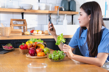 Diet, white-skinned young Asian woman in a blue shirt eating vegetable salad and apples as a healthy diet, opting for junk food. Female nutritionist losing weight. healthy eating concept.