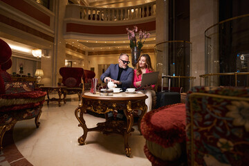 Traveling couple is resting from road in cozy seating area