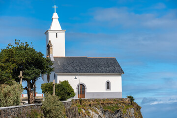 Fototapeta na wymiar Small chapel facing the sea on a cliff facing the Cantabrian Sea in Luarca, Asturias.