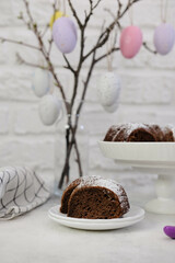 Easter background with eggs and spring branches. Happy Easter. Table setting with a piece of pie on white bricks background. Holidays background.