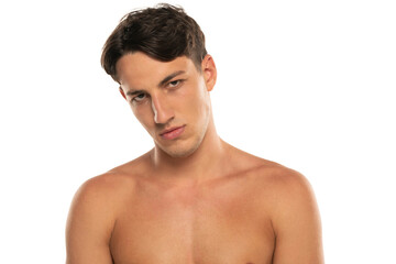 Closeup portrait of sullen half naked man 20s  looking at camera isolated over white background
